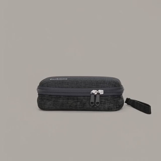 Démo : la pochette Packune s'ouvre et révèle ses 3 compartiments (poche zippée en filet, sangle élastique zigzag, poche filet ouverte) avec câbles, chargeur et écouteurs bien rangés